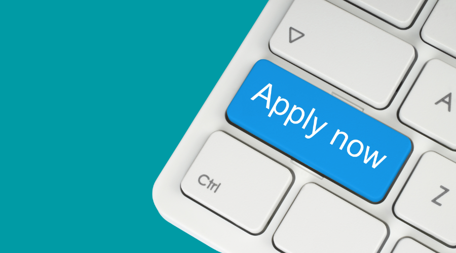A blue 'Apply now' button on a white keyboard.