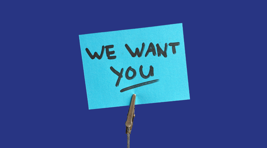 Writing on a light blue sticky note, which says 'We want you'.